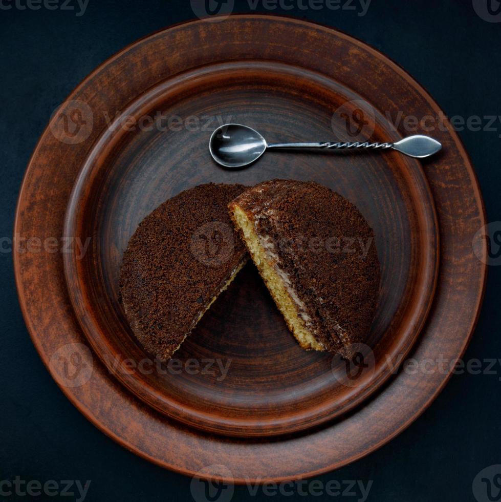 um bolo de tiramisu com uma colher de prata em um prato de barro. vista do topo. foto