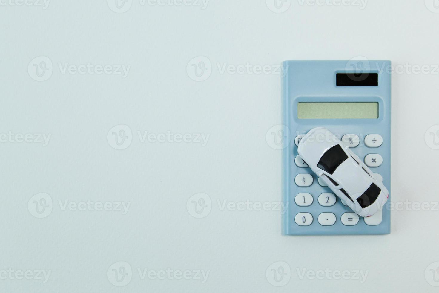 brinquedo de carro branco e fundo branco de calculadora azul. foto