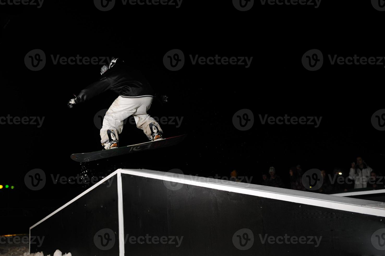 snowboarder freestyle pular no ar à noite foto