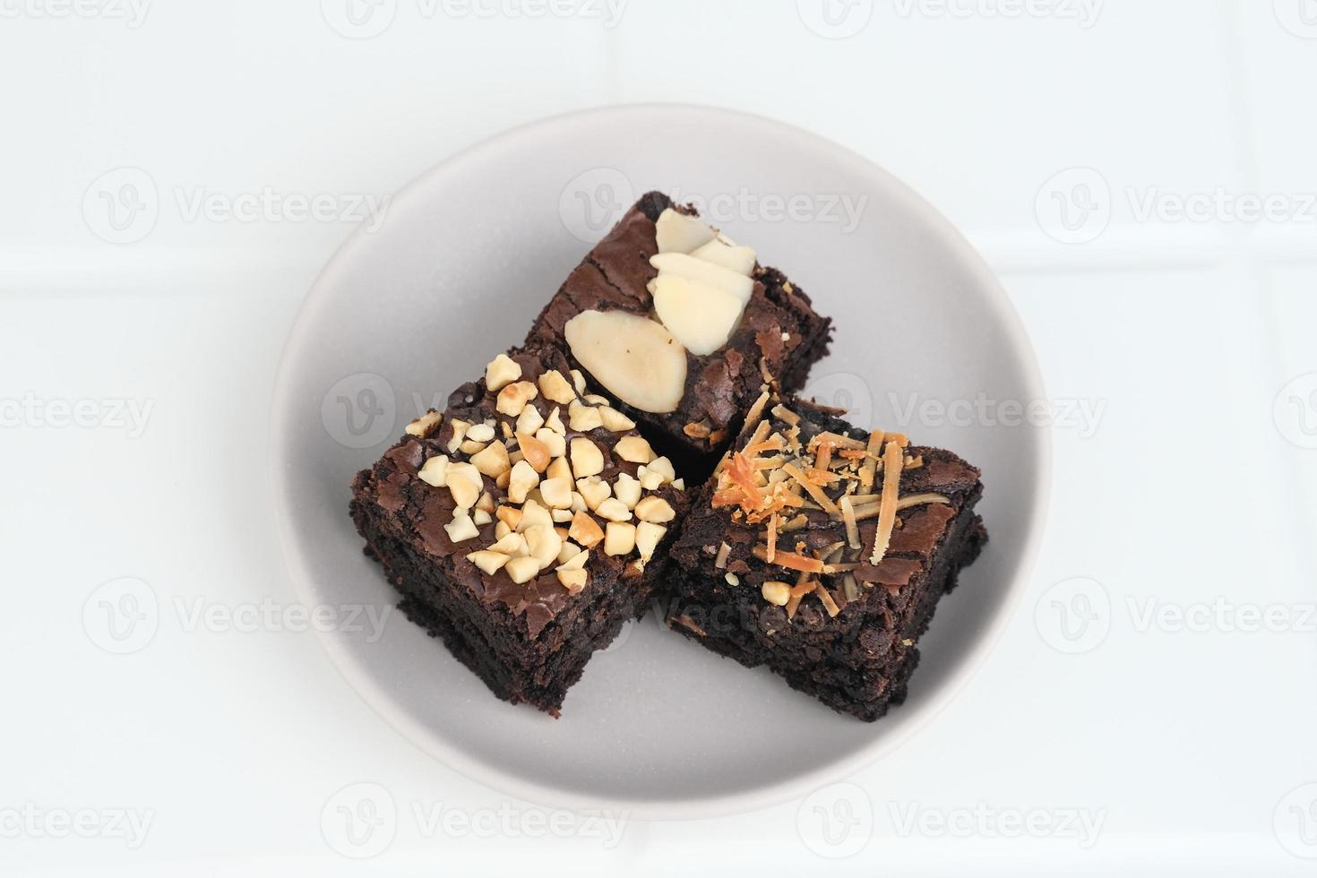 brownie de chocolate caseiro com cobertura de mistura, close-up, servido no prato, isolado no fundo branco. imagem de foco seletivo. foto