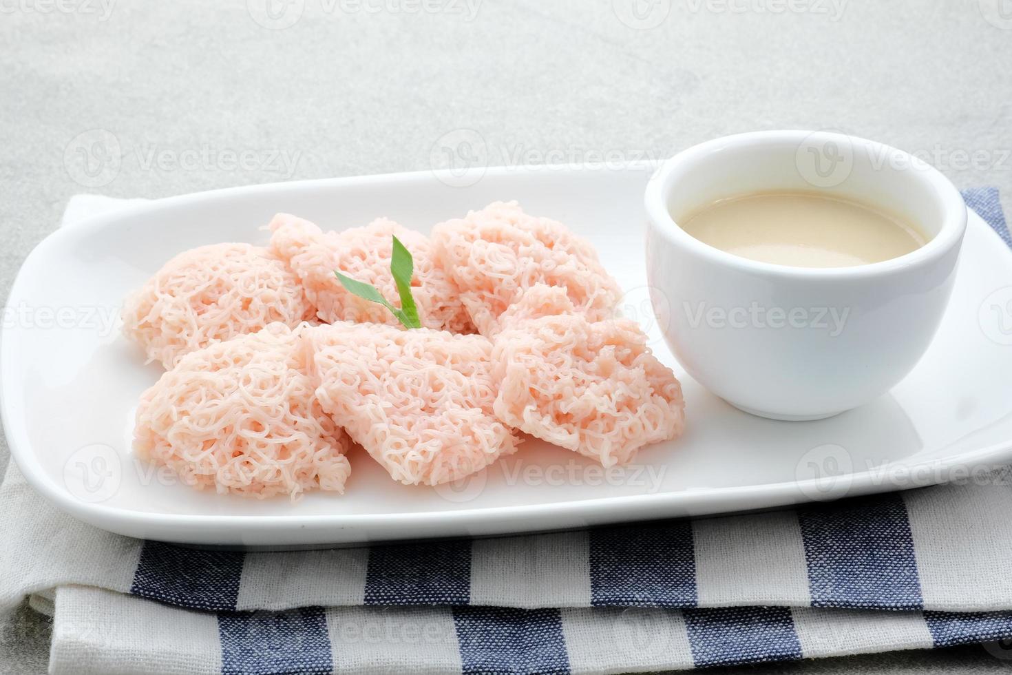 kue putu mayang é um lanche tradicional indonésio feito de fios de farinha de arroz enrolados em uma bola, servido com leite de coco e açúcar de palma. foto