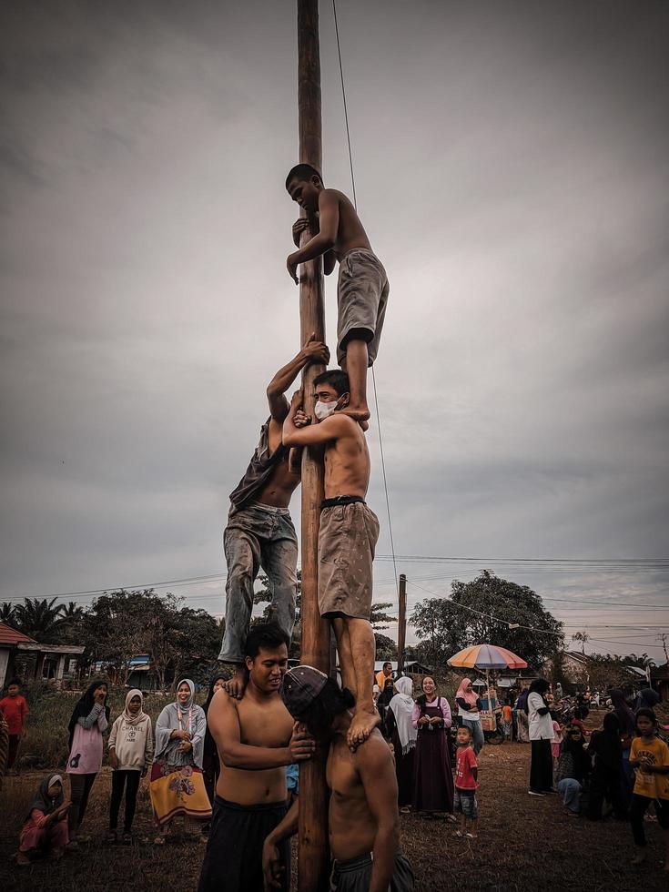 a emoção de crianças e adultos participando da competição de escalada areca para animar o dia da independência da república da indonésia, kalimantan oriental, indonésia, agosto, 14,2022 foto