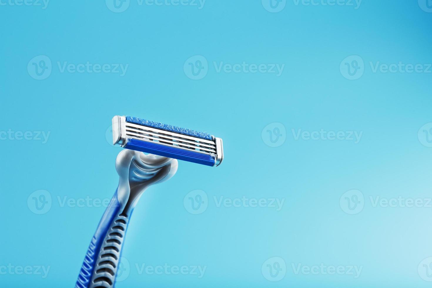 máquina de barbear com três lâminas em um espaço livre de close-up de fundo azul foto