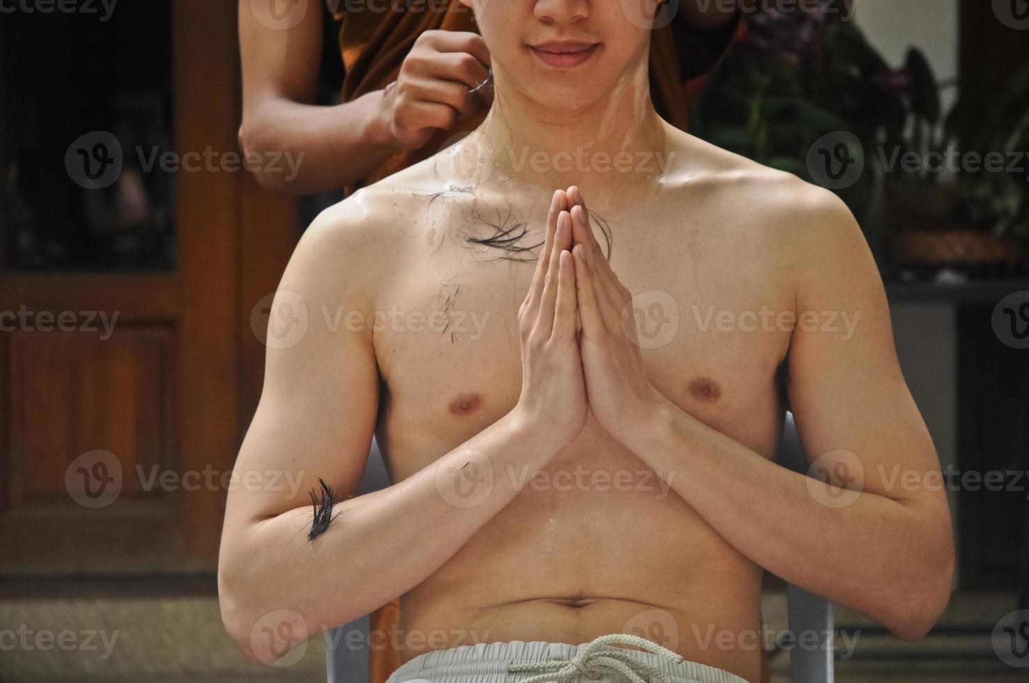 cortar o cabelo durante a meditação em uma ordenação para ser monge tailandês foto