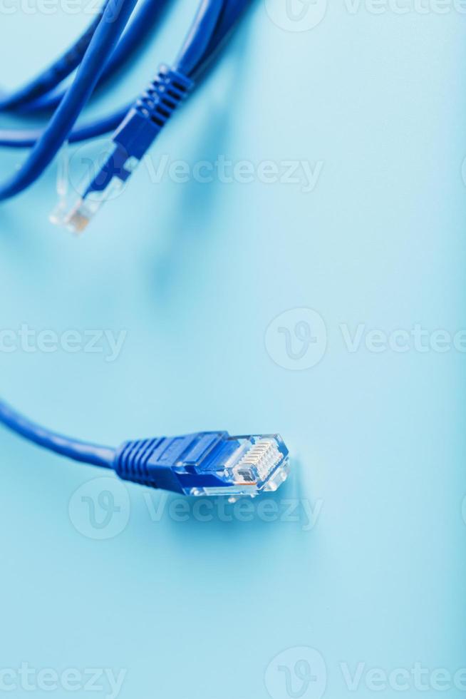 dois conectores de cabo ethernet cabo de remendo close-up isolado em um fundo azul com espaço livre foto