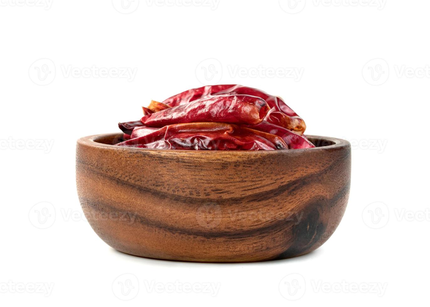 páprica moída vermelha ou pimenta seca em tigela de madeira isolada no fundo branco foto