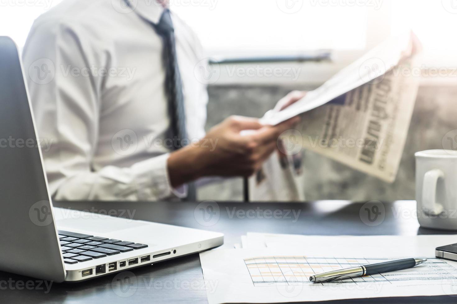 empresário lendo um jornal na mesa. foco seletivo foto