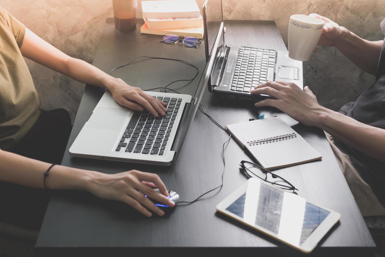 colegas de trabalho trabalhando na mesma mesa, eles estão usando um laptop com tablet, iniciar o conceito de negócios foto