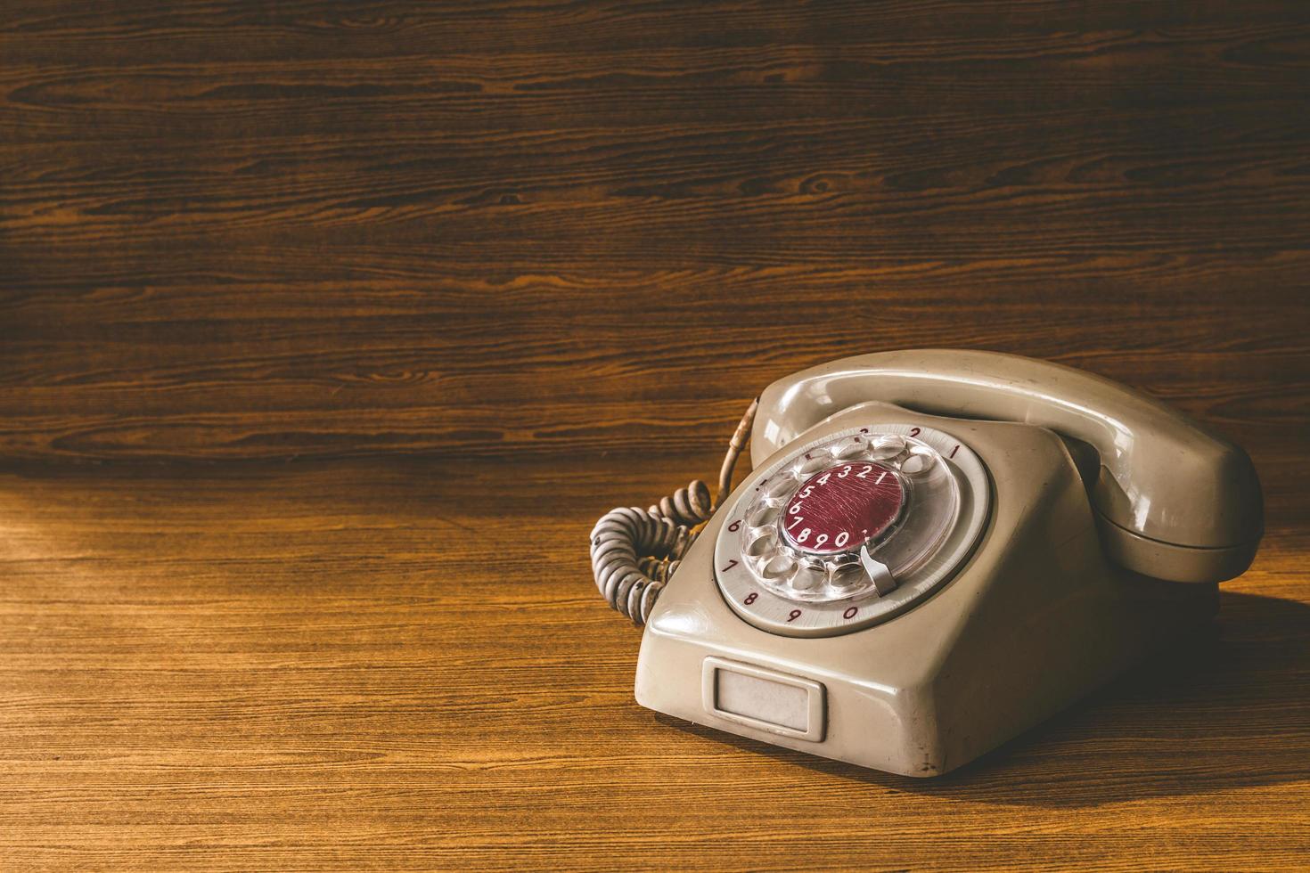 telefone antigo no fundo da mesa de madeira. foto