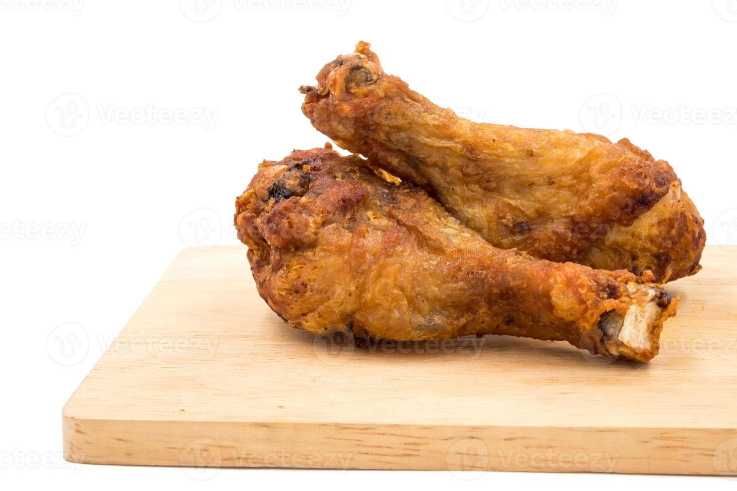 pernas de frango frito na bandeja de madeira sobre um fundo branco. foto
