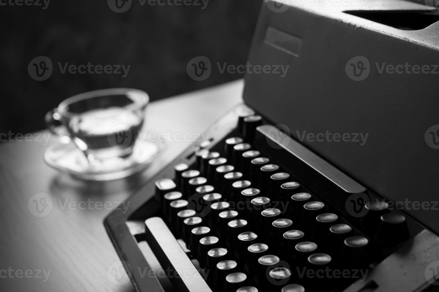 close-up da velha máquina de escrever em cima da mesa. tom preto e branco foto