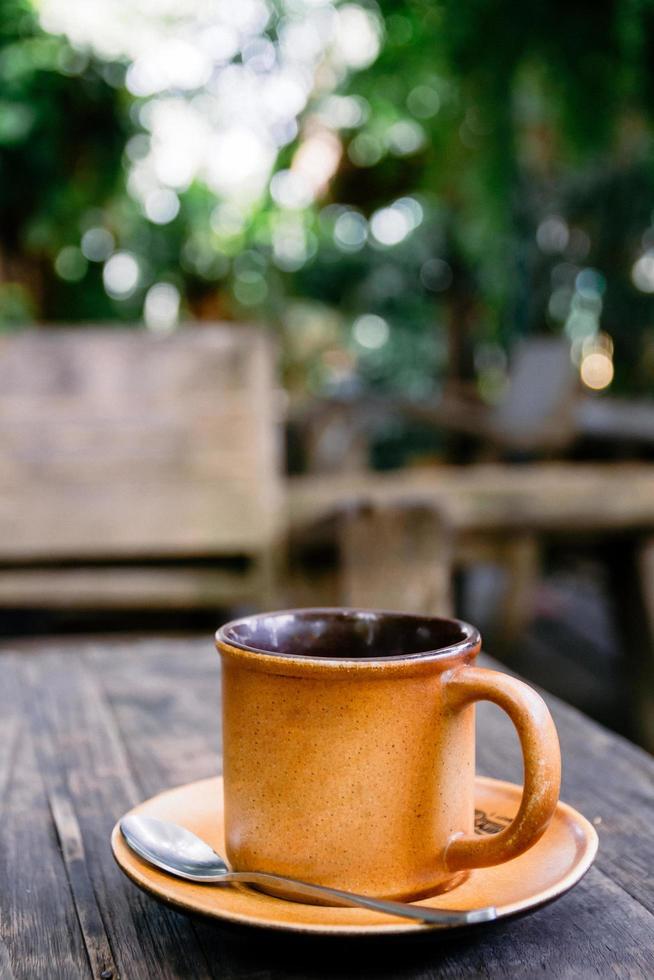 xícara de café na mesa de madeira no café. filtro de grãos de filmes. foto