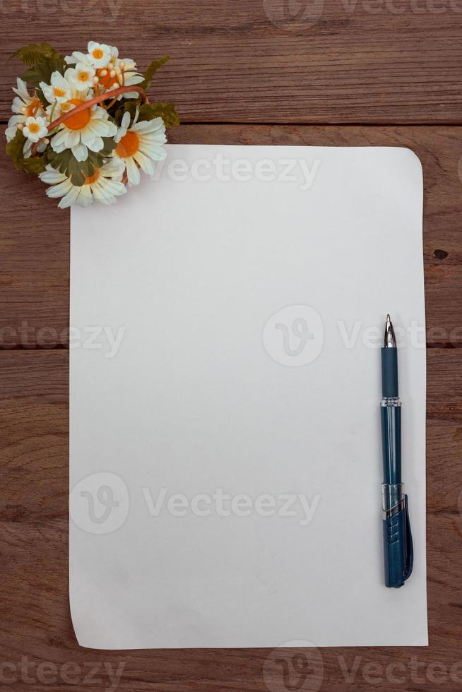 uma folha de papel com uma caneta na mesa de escritório de madeira, efeito de filtro. foto