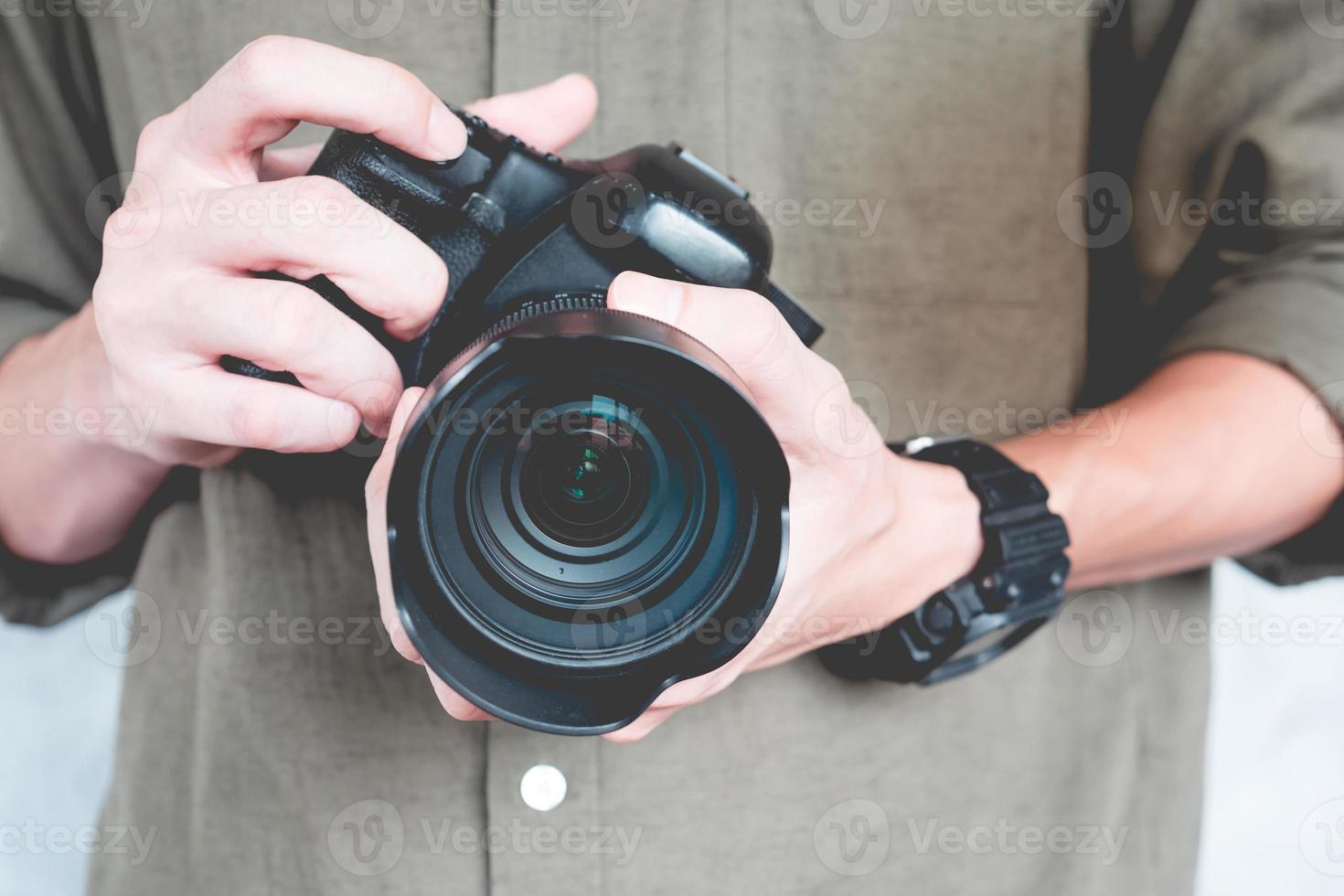 close-up de homem casual está segurando uma câmera, conceito de fotografia. foto