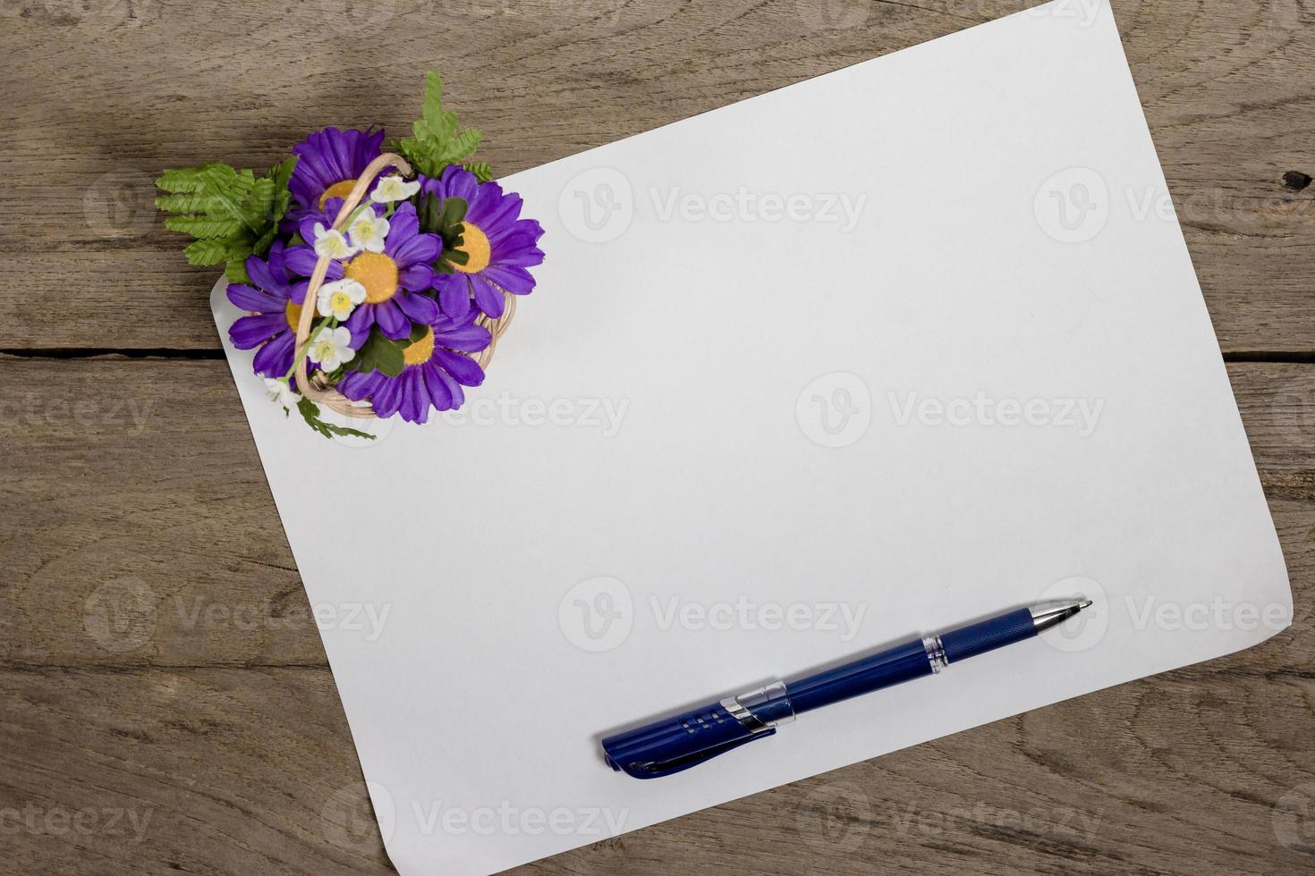 uma folha de papel com uma caneta na mesa de escritório de madeira foto
