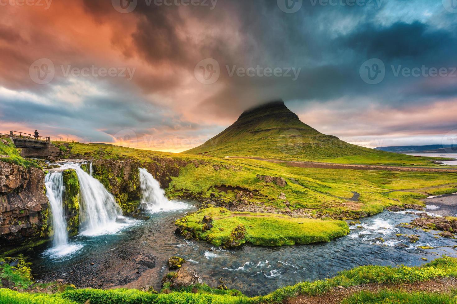 paisagem do pôr do sol sobre a montanha kirkjufell com cachoeira kirkjufellsfoss e nuvem colorida pileus no verão na islândia foto