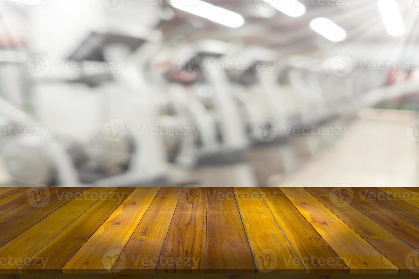 plataforma de espaço de tábua de madeira vazia com fundo de equipamento de ginástica de fitness desfocado foto