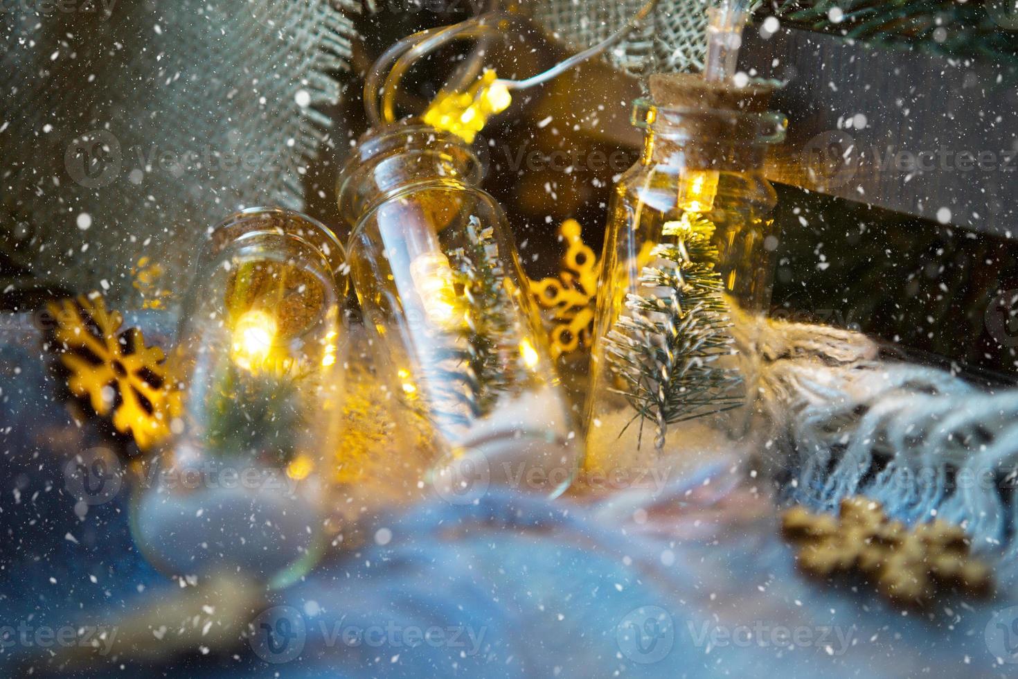 luzes de fada em uma jarra com uma árvore de natal e close-up de neve em uma manta aconchegante e aconchegante com decoração de madeira. natal e ano novo, decoração festiva, conforto em casa, preparação para celebração, clima fabuloso foto