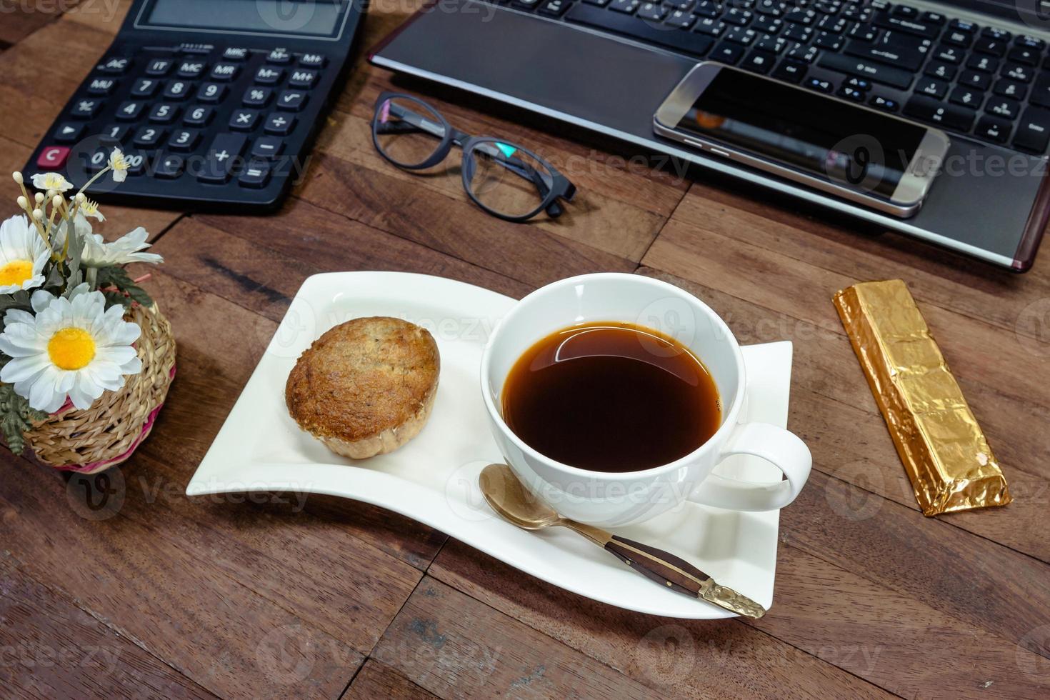 café com bolo de banana e equipamentos de escritório na área de trabalho foto