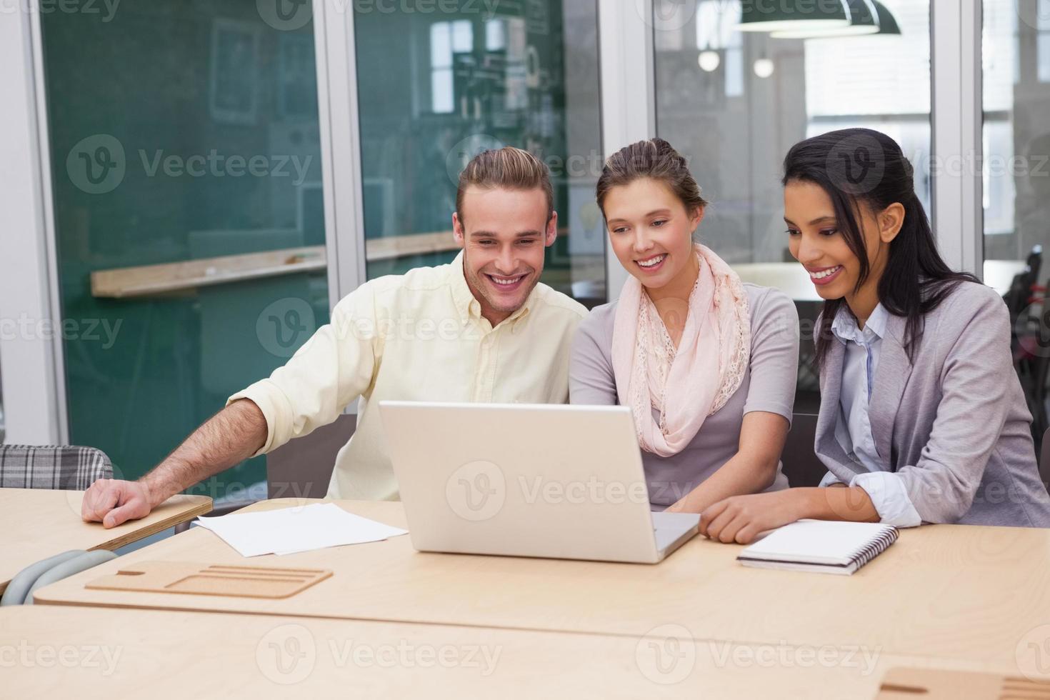 três empresários felizes trabalhando juntos em um laptop foto