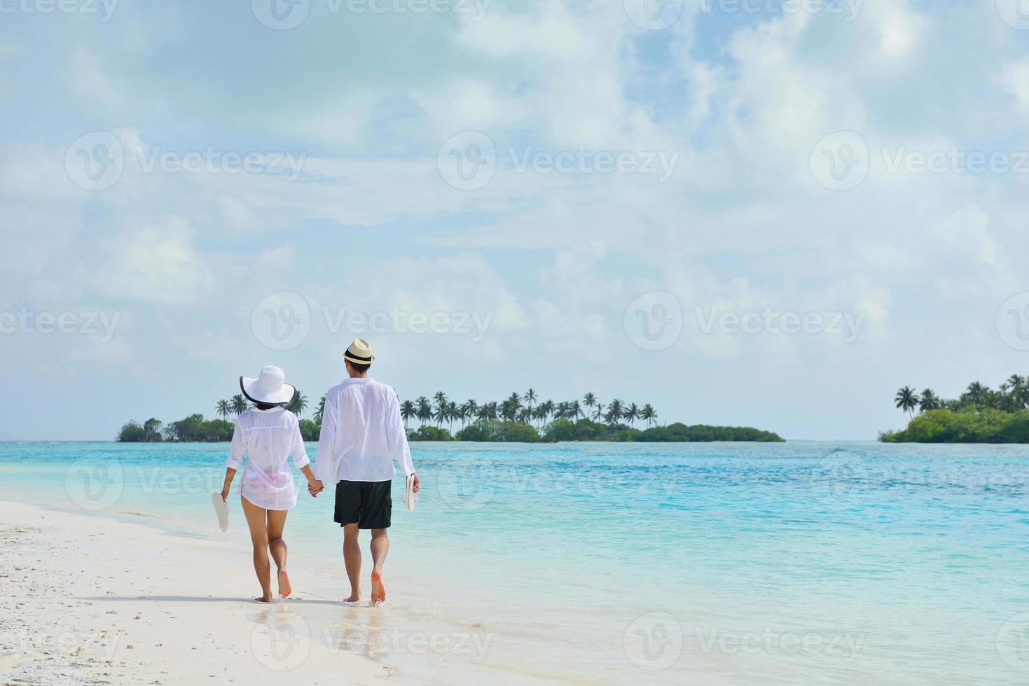 feliz casal jovem se divertir na praia foto