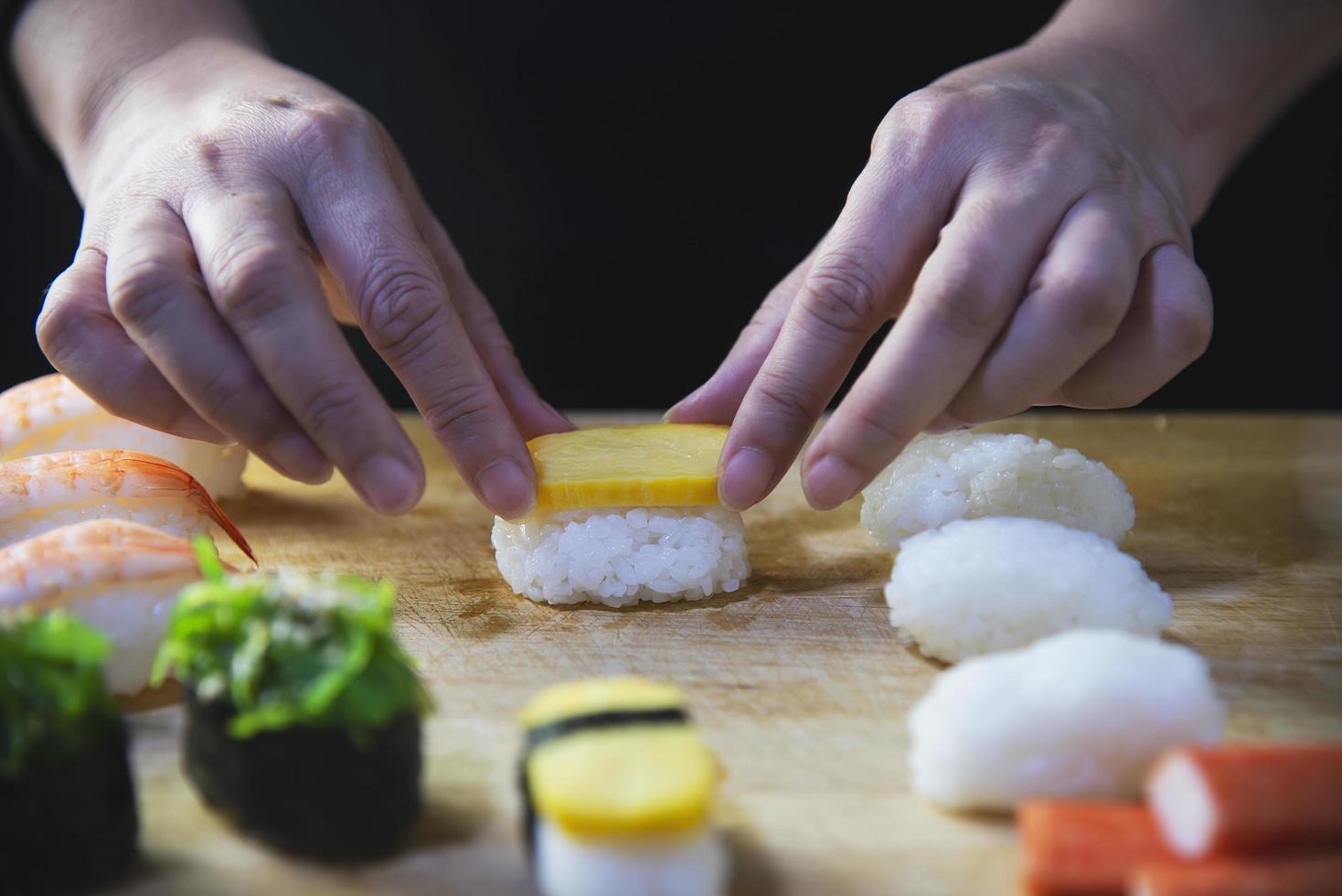 rolo de sushi maki japonês servindo no restaurante oriental, o chef está preparando o menu de culinária da tradição japonesa, vários conceitos de conjunto de alimentação saudável misto de luxo sortido diferente foto