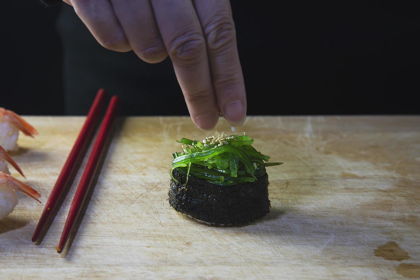 rolo de sushi maki japonês servindo no restaurante oriental, o chef está preparando o menu de culinária da tradição japonesa, vários conceitos de conjunto de alimentação saudável misto de luxo sortido diferente foto