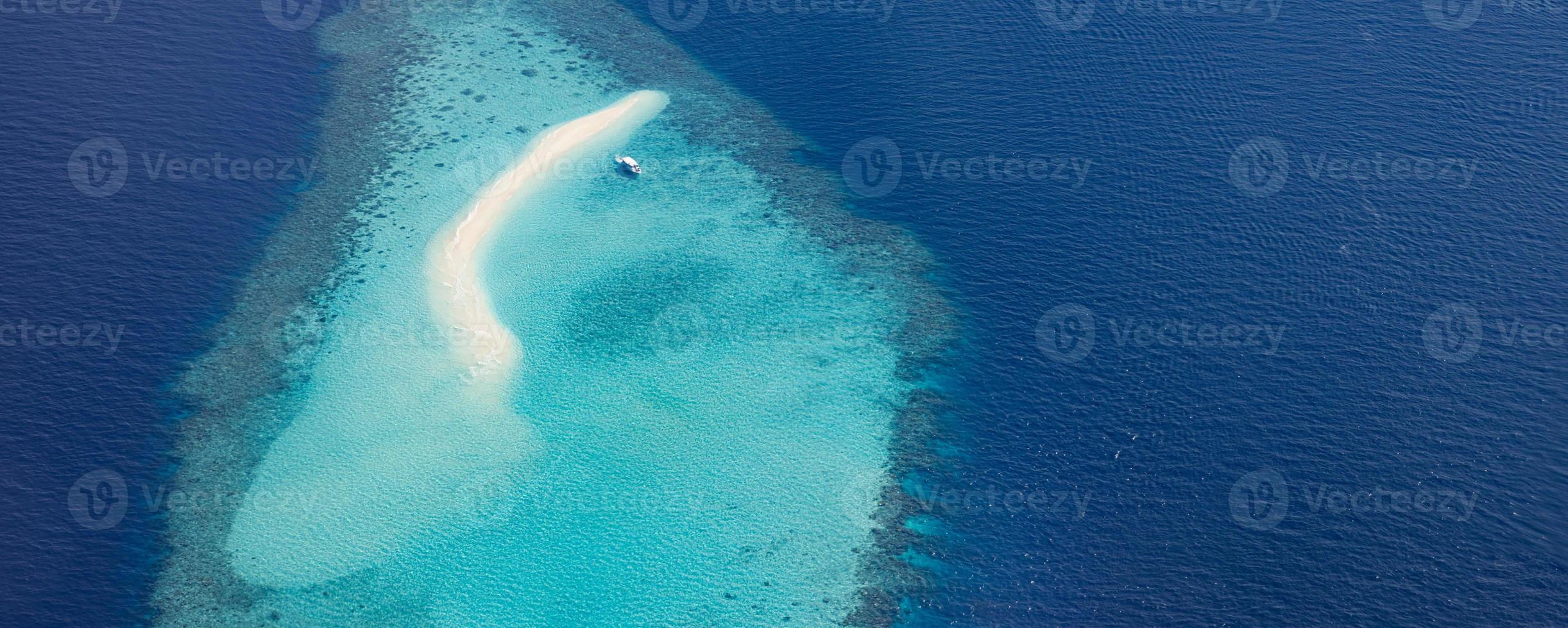 imagens aéreas da lagoa do oceano tropical azul turquesa, praia de areia branca, águas rasas de recifes de corais de banco de areia com um barco. perfeição da natureza no mar das maldivas. experiência de vida de luxo, paisagem pacífica foto