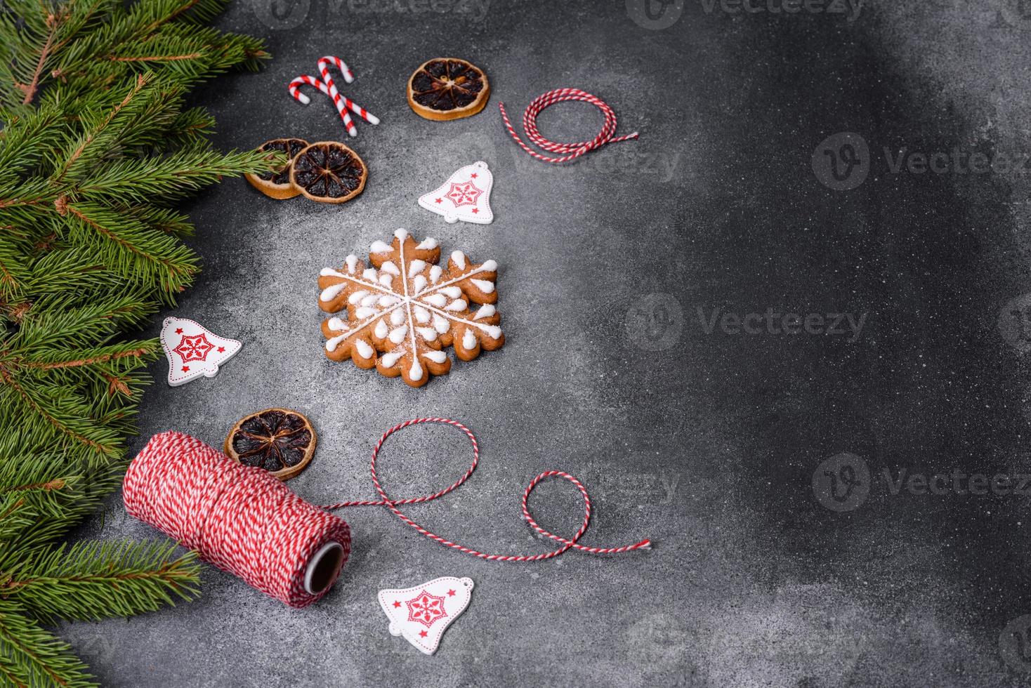 pão de gengibre, enfeites de árvore de natal, frutas cítricas secas em um fundo cinza de concreto foto