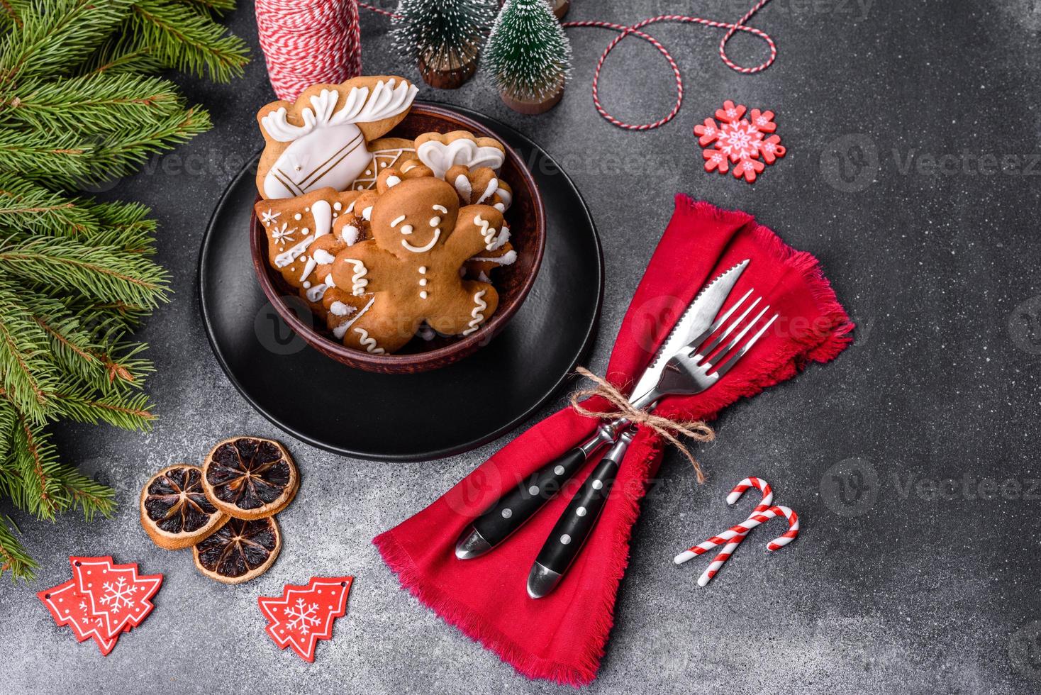 pão de gengibre, enfeites de árvore de natal, frutas cítricas secas em um fundo cinza de concreto foto