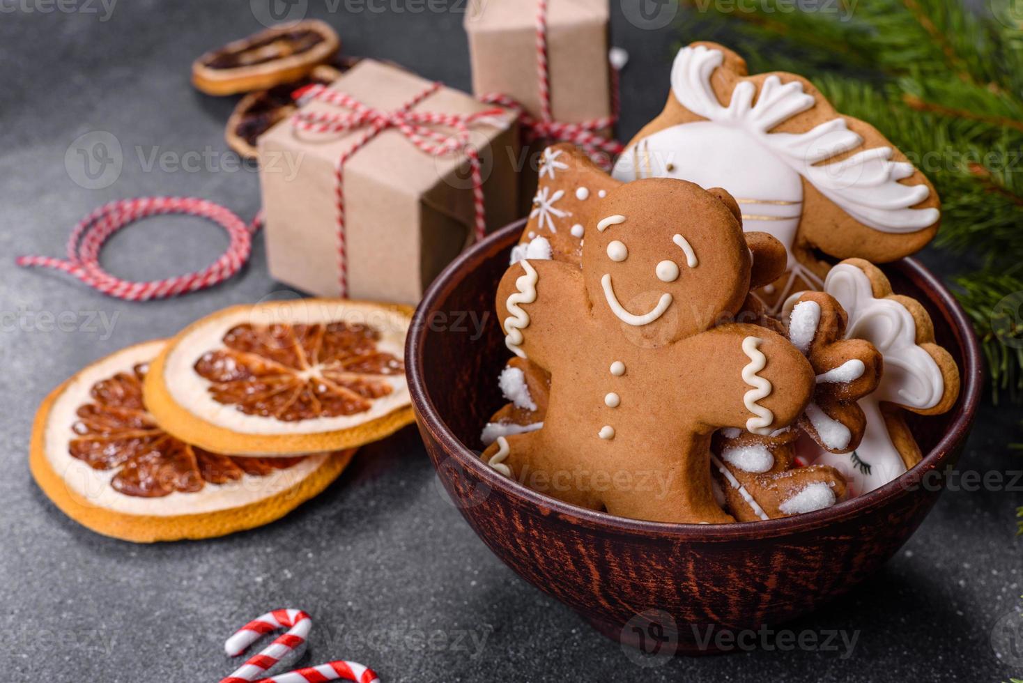 pão de gengibre, enfeites de árvore de natal, frutas cítricas secas em um fundo cinza de concreto foto