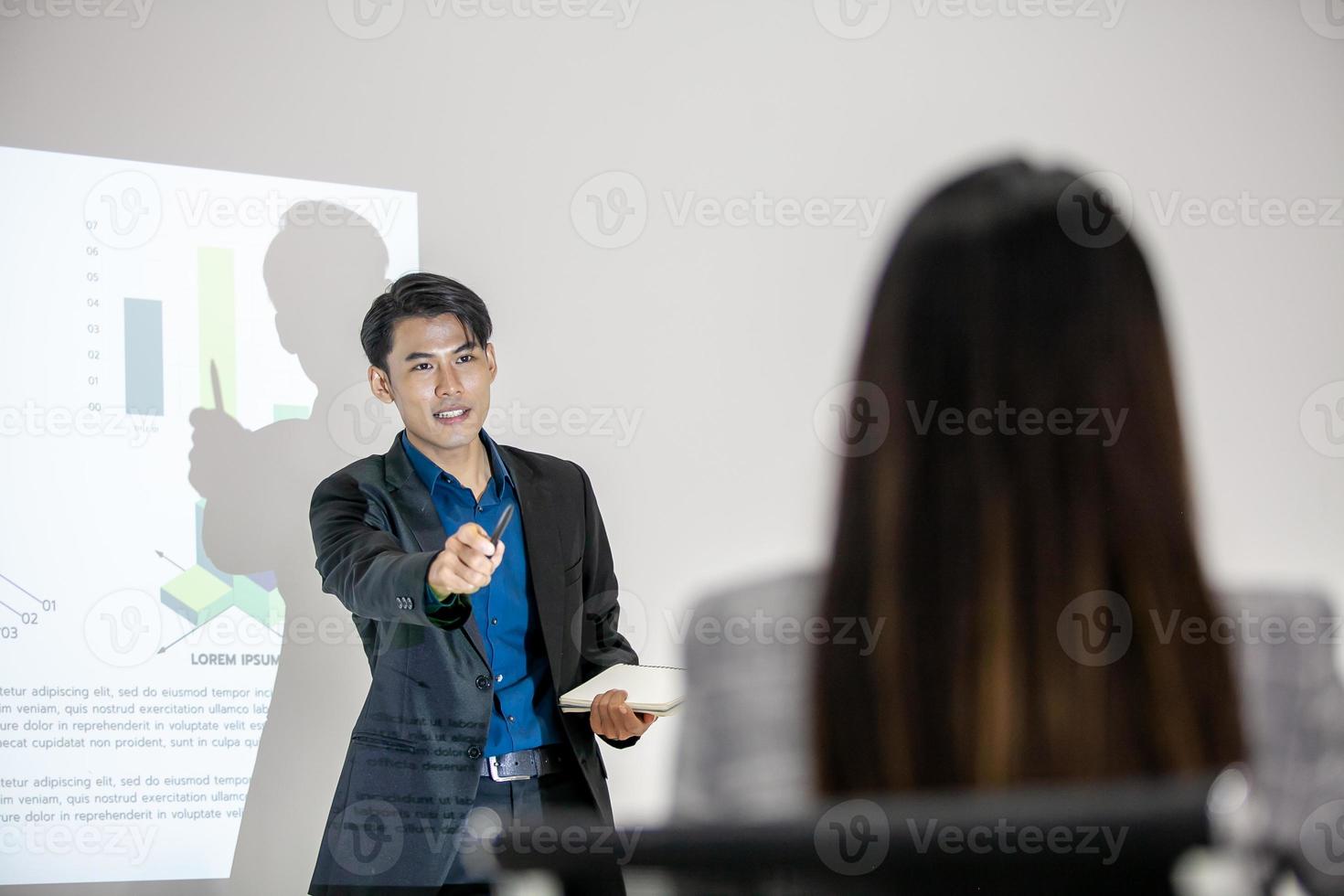 equipe de negócios asiáticos colegas masculinos e femininos conversando no trabalho compartilham ideias com gráfico a bordo, colegas levantaram as mãos para a pergunta. foto