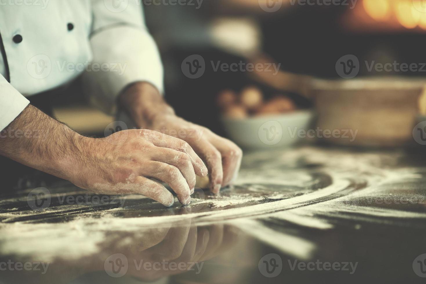 mãos de chef preparando massa para pizza foto