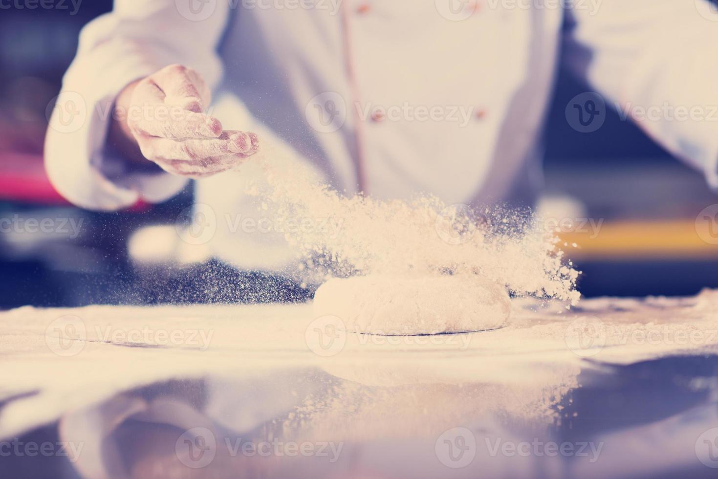 mãos de chef preparando massa para pizza foto