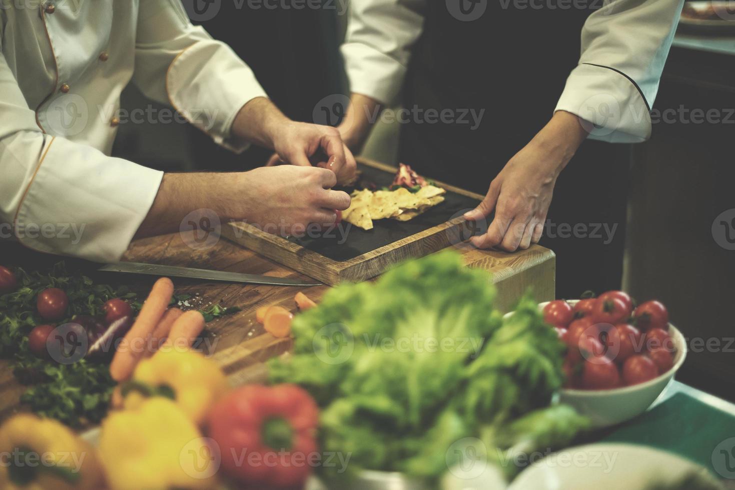 cozinheiros e chefs de equipe preparando a refeição foto