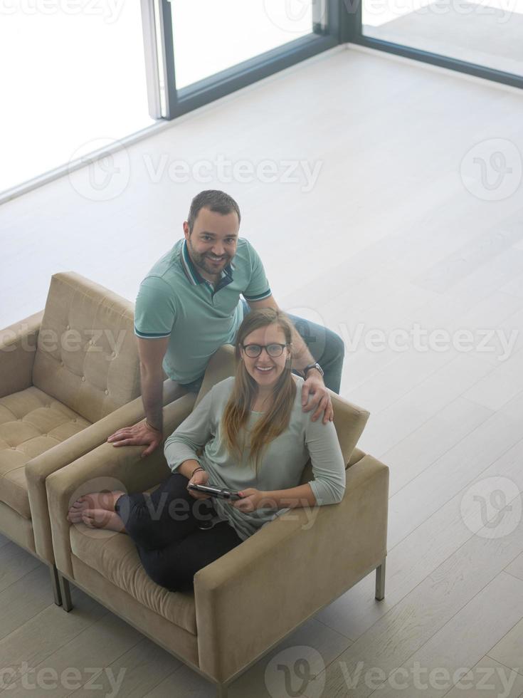 casal relaxando em casa com computadores tablet foto