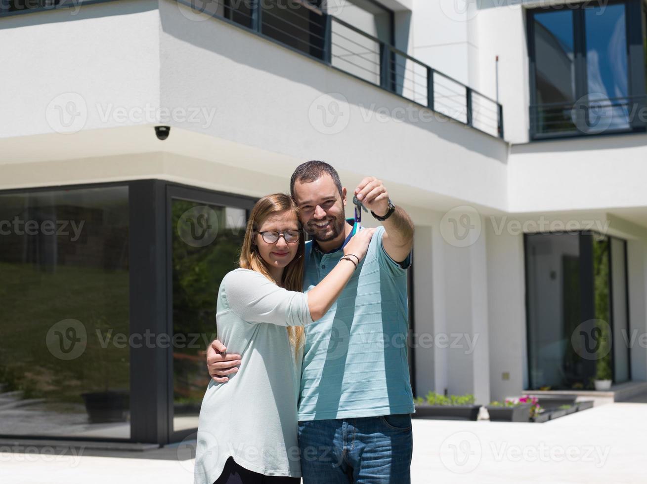 casal se abraçando em frente a nova casa de luxo foto