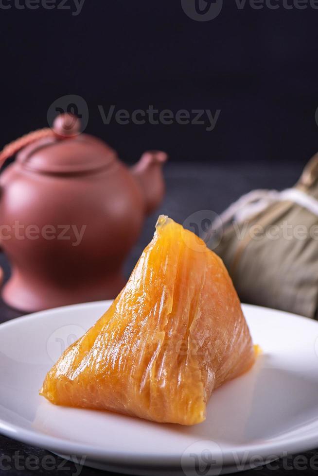 bolinho de arroz alcalino zongzi - comida de cristal chinesa doce tradicional em um prato para comer para o conceito de celebração do festival do barco dragão duanwu, close-up. foto