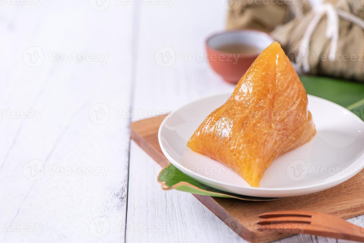 zongzi - comida de cristal de bolinho de arroz chinês alcalino em um prato para comer para o conceito tradicional do festival duanwu de barco-dragão, close-up. foto