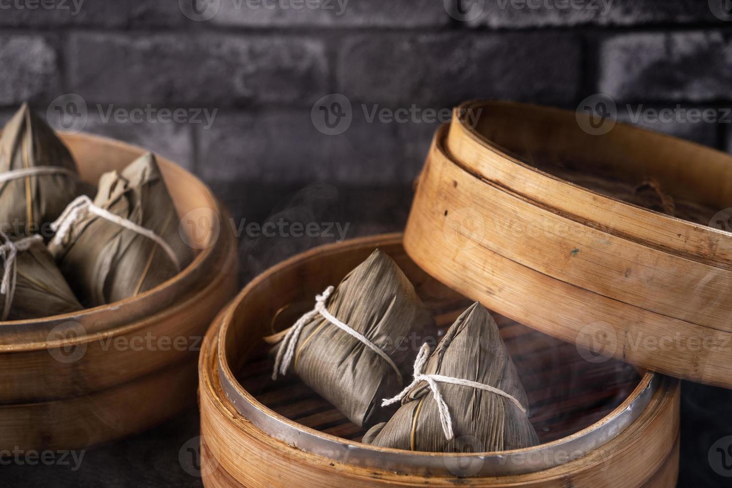 bolinho de arroz, zongzi - bolinho de arroz chinês zongzi na mesa de ardósia de fundo de tijolo preto, conceito de comida tradicional do festival do barco dragão, close-up. foto