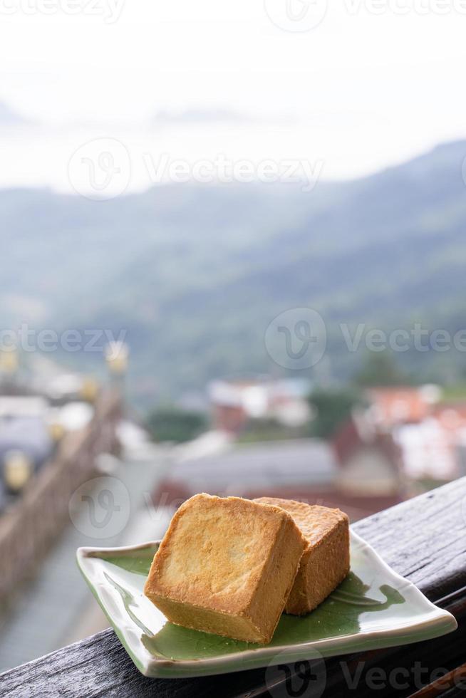 deliciosa massa de abacaxi em um prato para o chá da tarde na grade de madeira de uma casa de chá em taiwan com bela paisagem ao fundo, close-up. foto