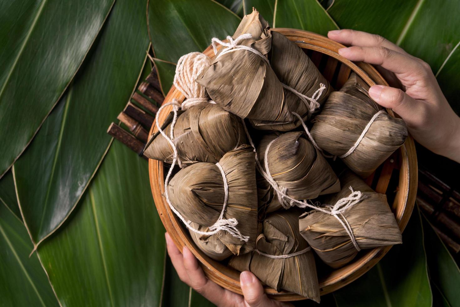 bolinho de arroz, zongzi - comida chinesa tradicional no fundo da folha verde do festival do barco dragão, festival duanwu, vista superior, conceito de design plano leigo. foto