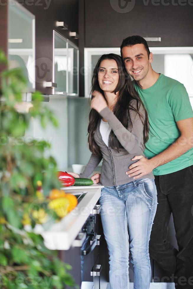 jovem casal se diverte na cozinha moderna foto