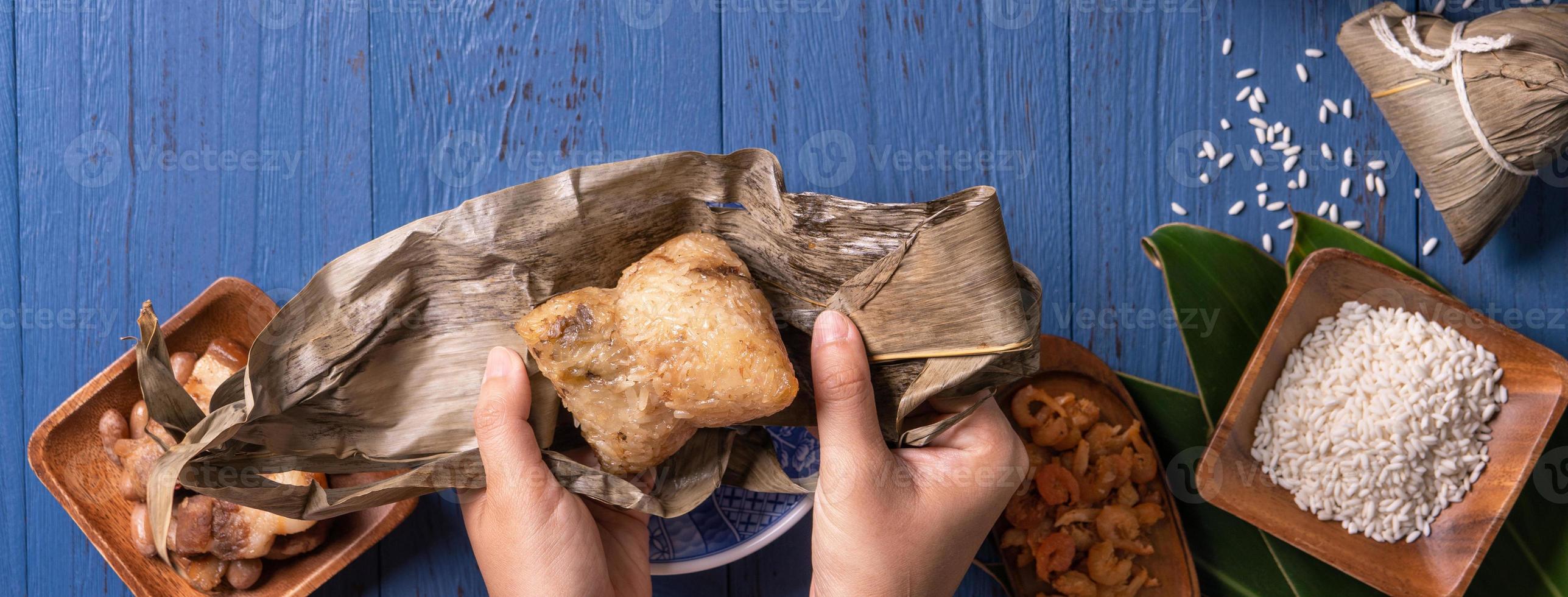 conceito de festival de barco de dragão - bolinho de arroz, zongzi, comida tradicional chinesa em fundo azul de madeira para festival duanwu, vista superior, conceito de design plano leigo. foto