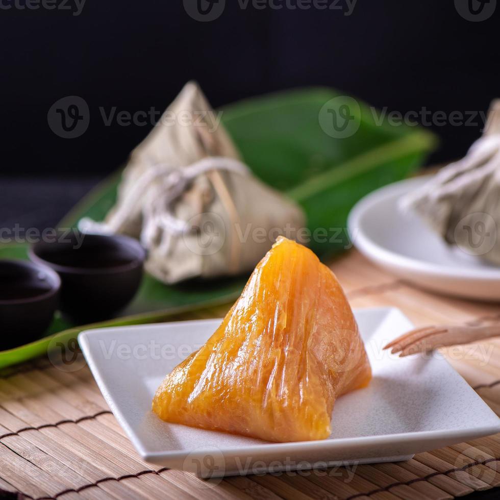 bolinho de arroz alcalino zongzi - comida de cristal chinesa doce tradicional em um prato para comer para o conceito de celebração do festival do barco dragão duanwu, close-up. foto