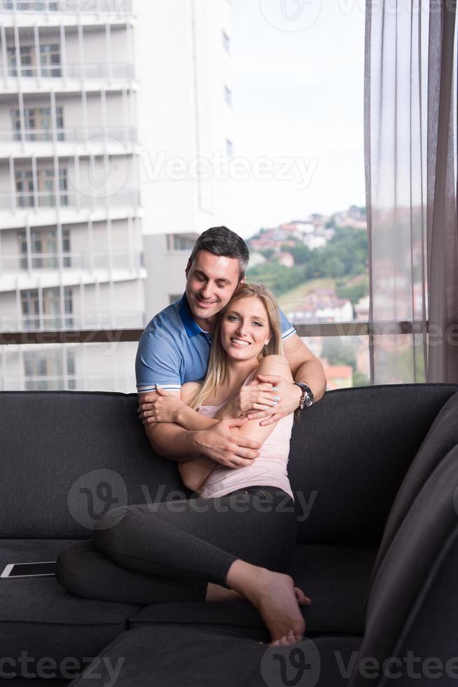 jovem casal bonito abraçando no sofá foto