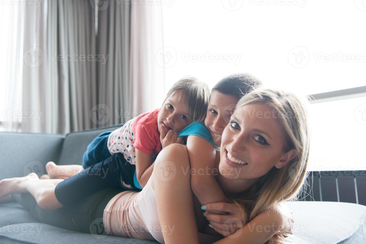 jovem mãe passando tempo com crianças no chão foto