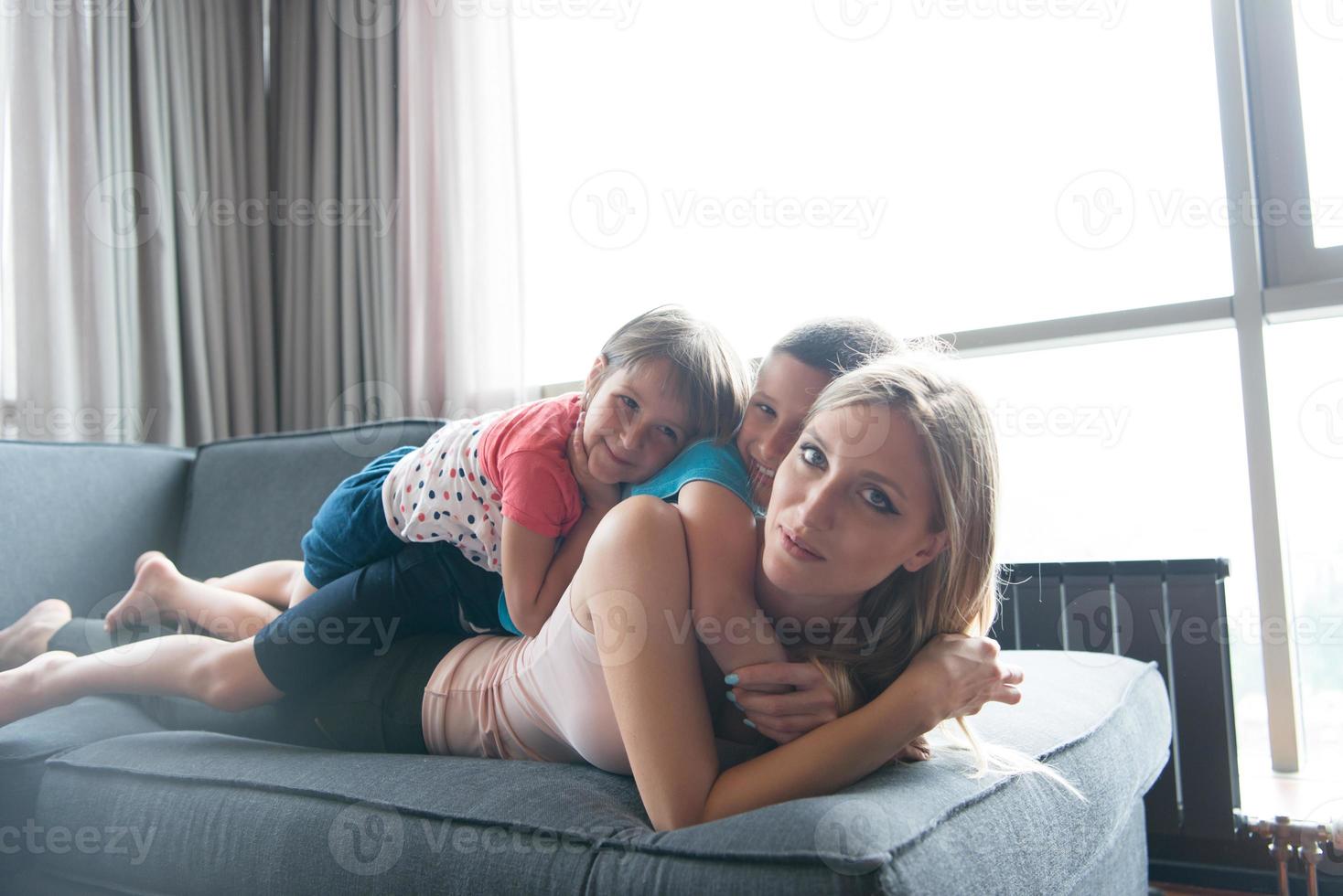 jovem mãe passando tempo com crianças no chão foto