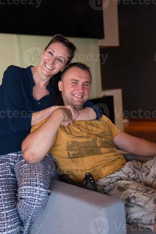 jovem casal bonito abraçando no sofá foto