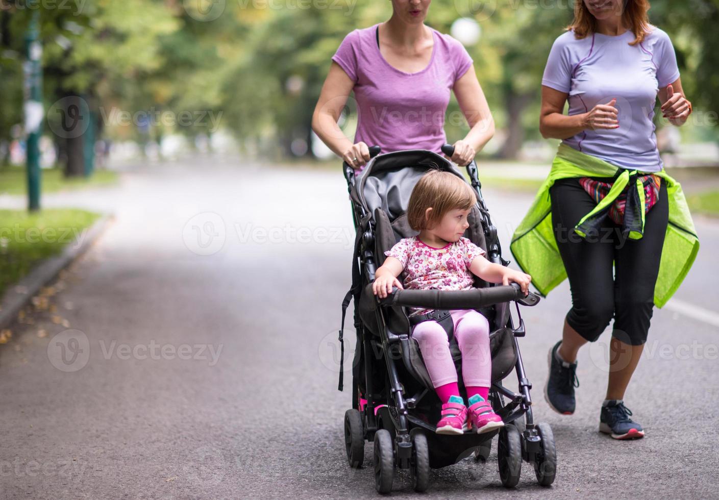 mulheres com carrinho de bebê correndo juntos foto